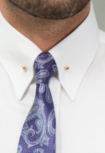 Zbliżenie na kołnierz eleganckiej koszuli męskiej w kolorze białym oraz niebieski krawat